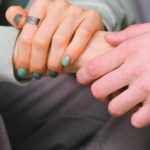 A close up of two people holding hands