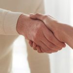 Two people shaking hands in a room.