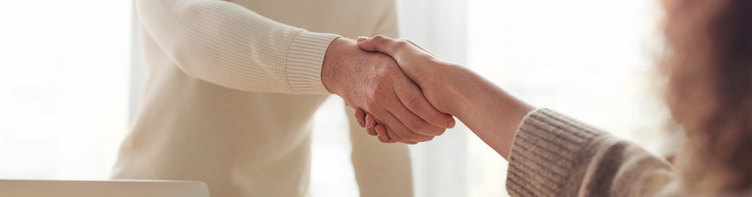 Two people shaking hands in a room.