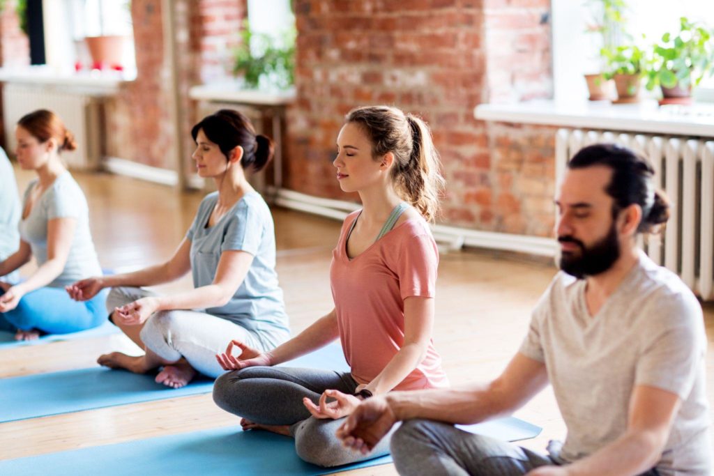 group of people making yoga exercises